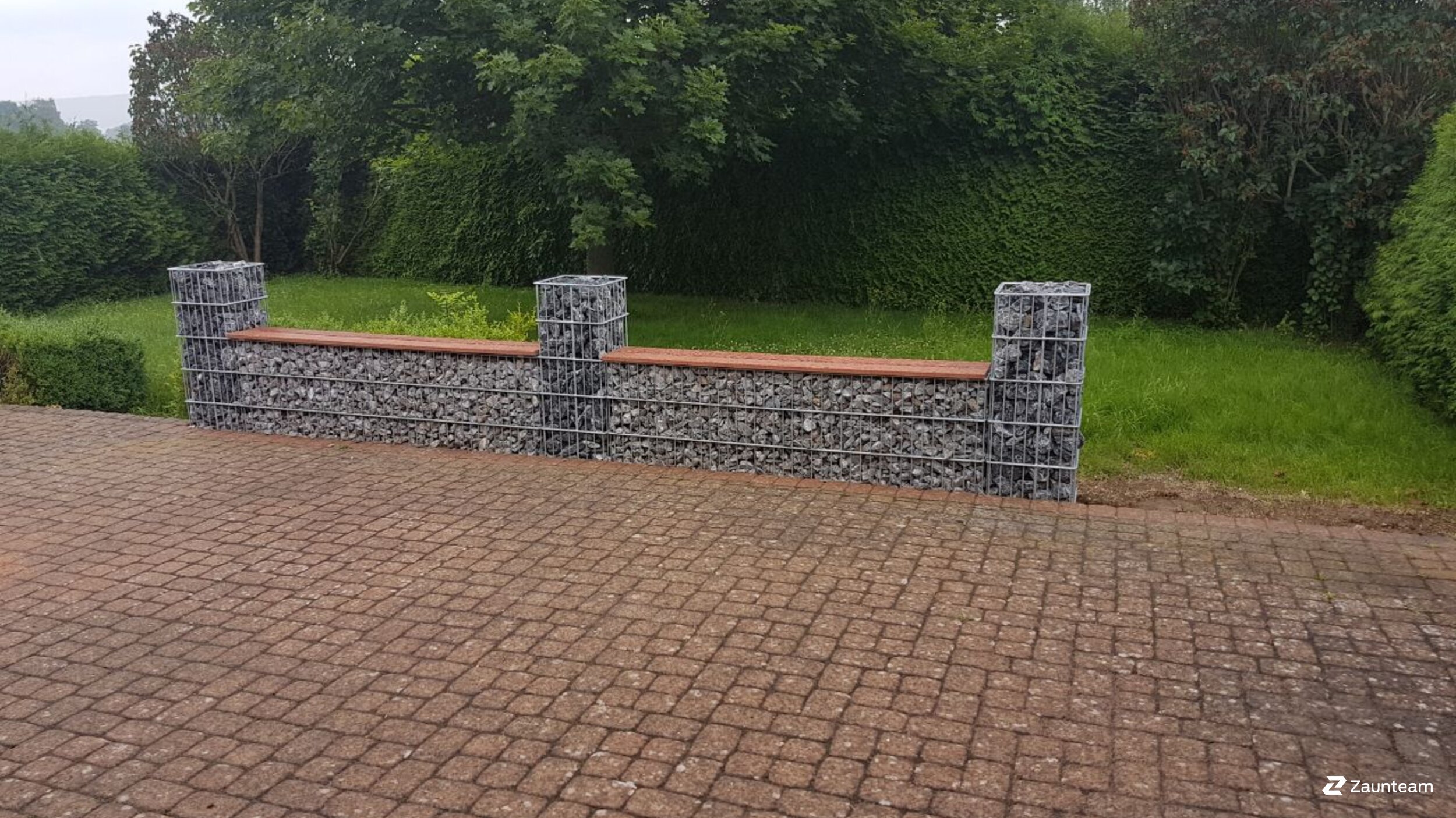 Steinsäulen und Steinkörbe als Sichtschutz von Zaunteam