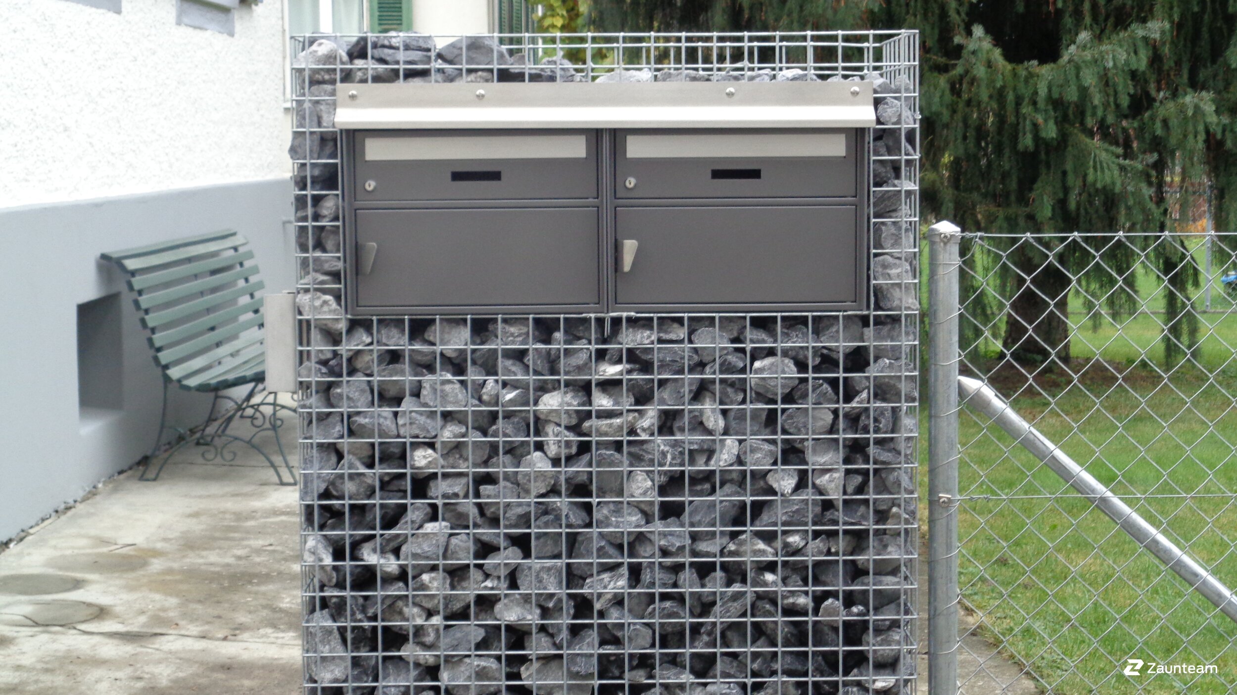 Boîte aux lettres dans des colonnes en pierre et des gabions