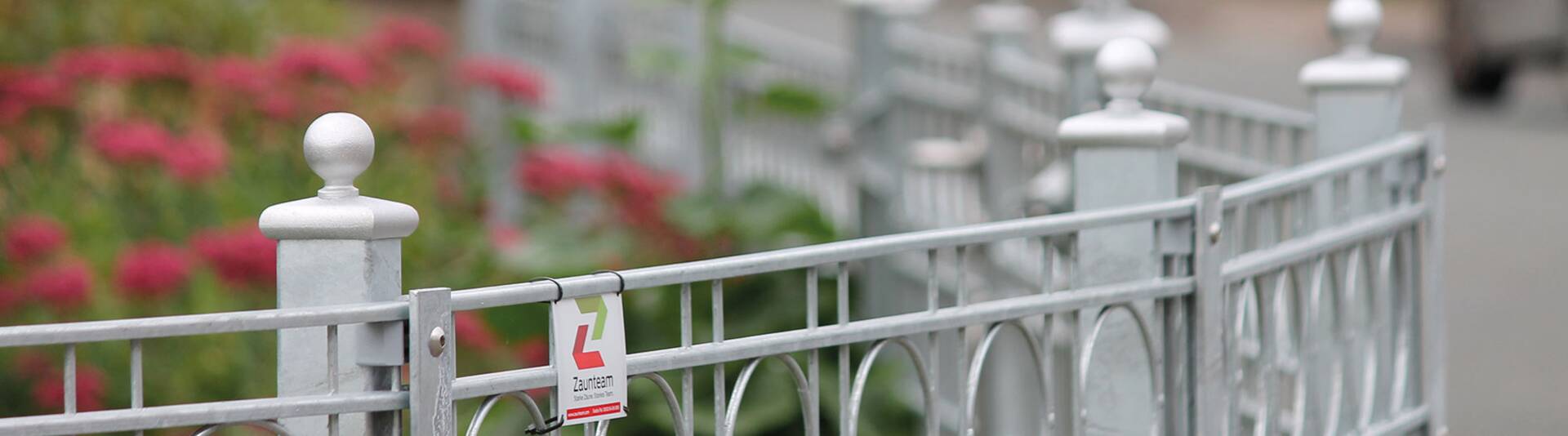 Unser Bild zeigt einen dekorativen Metallzaun, der Ihrem Garten eine elegante Note verleiht. Der Zaun ist mit filigranen Mustern und Details verziert, die ihm ein kunstvolles Aussehen verleihen. Er besteht aus hochwertigem Metall und ist langlebig und robust. Dieser dekorative Zaun ist die perfekte Wahl, um Ihren Garten stilvoll zu umgeben und ihm eine besondere Atmosphäre zu verleihen. | © Zaunteam