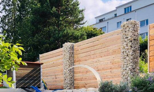 Dies ist ein simples, aber effektives System. Die einzelnen Bohlen werden aneinander in die U-Profil-Pfosten gesetzt. Dadurch entsteht eine dichte Wand, die den gewünschten Schutz bietet. | © Zaunteam