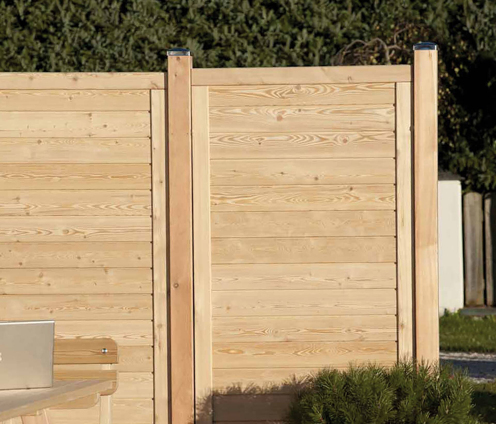 Der Sichtschutz aus Holz "Zermatt" eignet sich hervorragend als Sicht- und Lärmschutz. Der Holz Sichtschutz Zermatt ist aus naturbelassener Lärche mit vertikalen eher breiteren Lamellen, die in einem soliden Rahmen verschraubt sind und so optimale Stabilität und Sicherheit bieten. | © Zaunteam