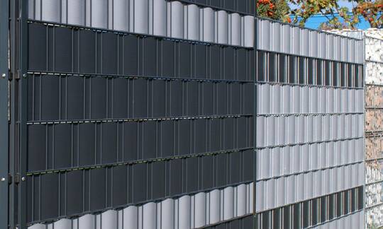 Dieser setzt auf die Vorteile von Metall und Kunststoff. Ebenso starke wie flexible Streifen aus Hart-PVC werden in genormte und voll verzinkte Stahlgitter-Elemente eingeflochten. | © Zaunteam